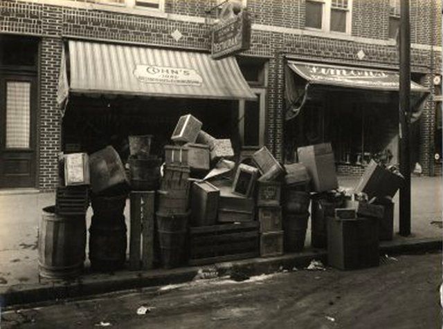 "2042-86th Street, Brooklyn. Cohn's Restaurant & Dining Room. Crates, barrels, boxes, cans stacked on curb."